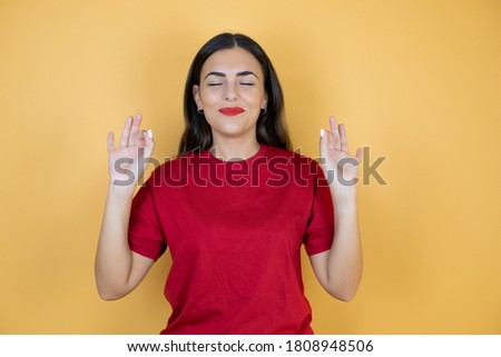 Young beautiful woman over isolated yellow background relax and smiling with eyes closed doing meditation gesture with fingers.