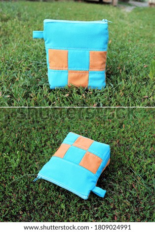 Handmade patchwork textile bag for cosmetics on the lawn. Collage