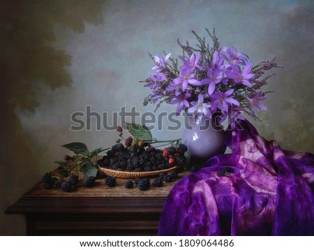 Still life with bouquet of purple flowers and blackberries
