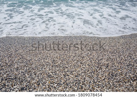 The beach of the Mediterranean coast with waves of azure water. Summer sea breeze