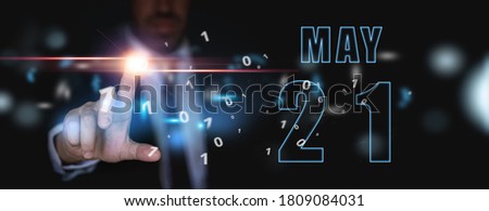 may 21st. Day 20 of month, advertising or high-tech calendar, man in suit presses bright virtual button spring month, day of the year concept.