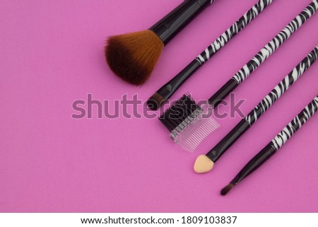 Makeup set on pink background with room for text