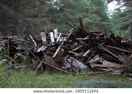 Huge pile of construction waste stacked in the forest waiting to be burnt, recycled. Renewable bio energy for autonomous and self-sustainable heating system.