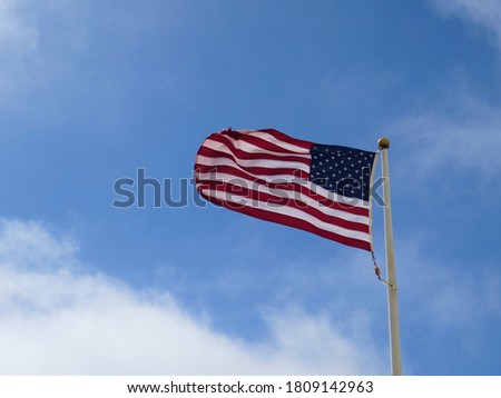 USA flag waving on blue sky with clouds