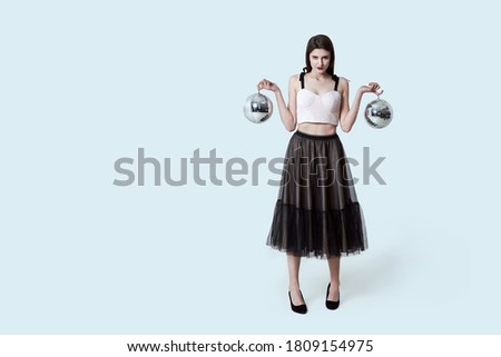 Young beautiful brunette girl in dark box pleated midi skirt posing in studio.