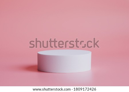 White podium on a pink background, for the presentation of products and cosmetics.