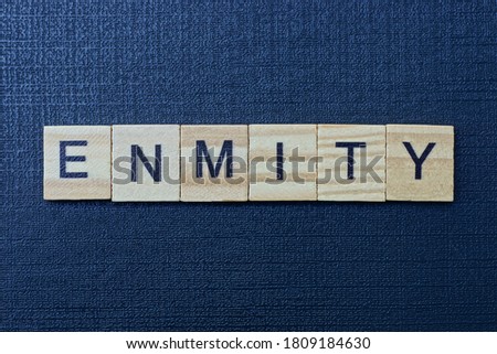 gray word enmity from small wooden letters on a black table Royalty-Free Stock Photo #1809184630