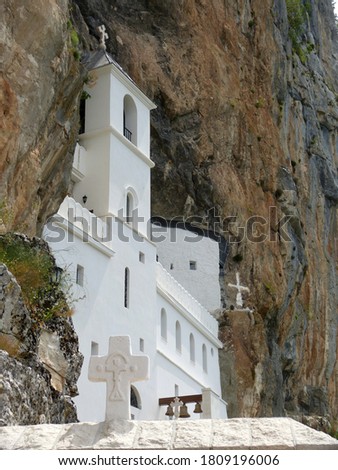Ostrog is monastery of Serbian Orthodox Church situated against an almost vertical background, high up in  large rock Ostroska Greda. Beautiful white temple on steep cliff in mountains of Montenegro. Royalty-Free Stock Photo #1809196006