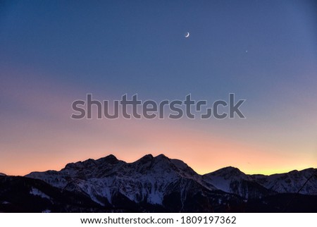 Moon and planet Venus in the sunset lights over the mountains Royalty-Free Stock Photo #1809197362