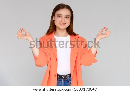 young smiling woman meditating, holding her hands in yoga gesture, feeling calm and positive, isolated on white studio background