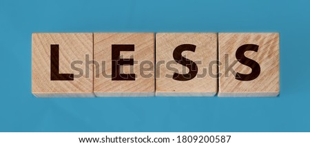 Less word on wooden cubic blocks with letters. Spend less or cut costs business concept.