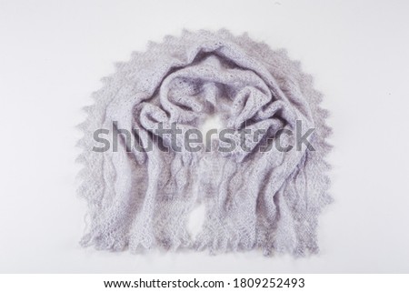 top view on folded handmade grey woolen scarf with knitted pattern in russian old style on light gray background