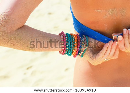 Closeup picture of a young woman fixing her swimsuit