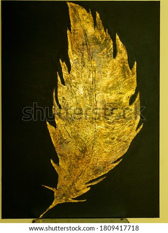 Metal Golden feather on black background. Gold glitter texture. Abstract painting. Art object