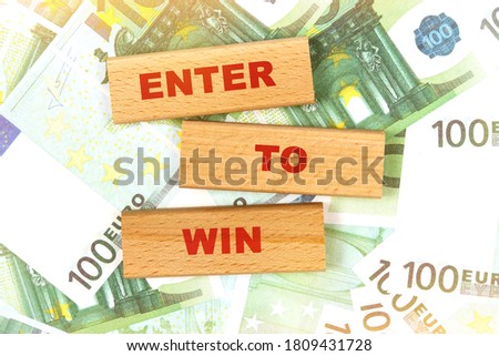 Business concept. Against the background of euro bills, the text is written on wooden blocks -ENTER TO WIN