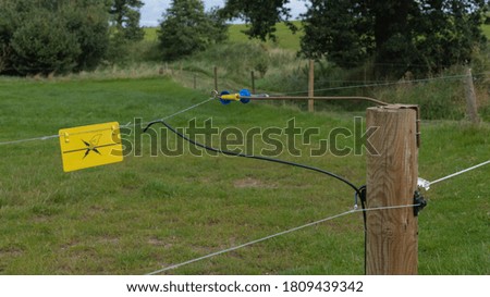 Fence with electric wire in a field
