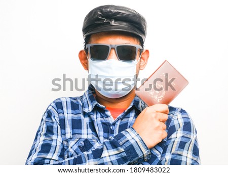 A picture of men playing as tourist wearing face mask and holding passport on isolated white background. Precautious step taken travel during covid-19 pandemic.