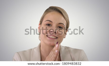 Portrait of happy woman with beaming smile talking to camera on gradient background.