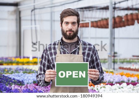 Male Garden Worker Holding an Open Signboard