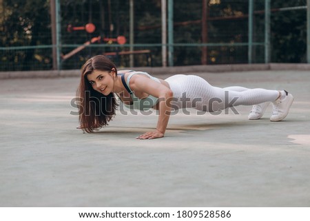 Woman athlete doing push ups exercise on the ground