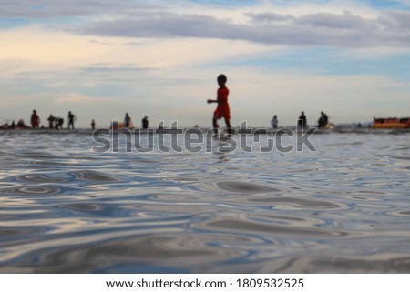 The blurred shadow of the child playing in the sea with beautiful spiral waves​