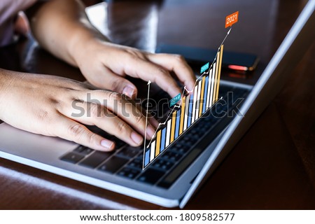Businessman using a laptop with data analytics and statistics information business technology on table top. Royalty-Free Stock Photo #1809582577