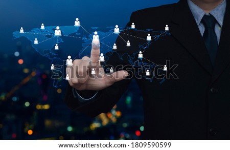 Hand click businessman icon with world map connection lines over blur colorful night light city tower and skyscraper, Business communication concept, Elements of this image furnished by NASA