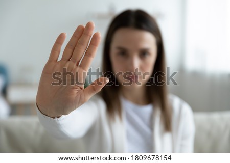 Close up focus on female hand showing stop gesture, protesting against domestic abuses or violence. Decisive woman saying no to abortion, denying gender discrimination, nonverbal language concept.