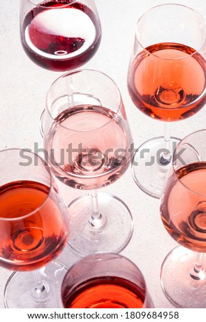 Rose wine glasses set on wine tasting. Degustation different varieties, colors and shades of pink wine concept. White background, top view Royalty-Free Stock Photo #1809684958