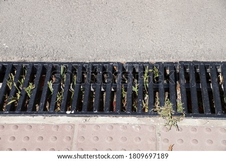 cast iron street drainage on the sidewalk