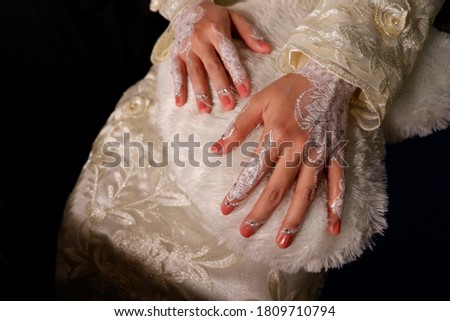 Women's hands are being painted on hena