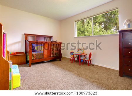 Simple baby room with cherry wood crib and toys
