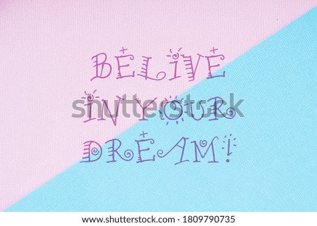 Motivational quote on a pink and blue background. Believe in your dream!