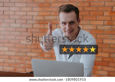 Smiling businessman use computer laptop reviews rating with Five Star.