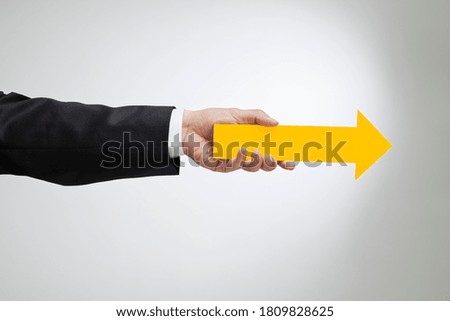 A businessman with a yellow arrow in his hand