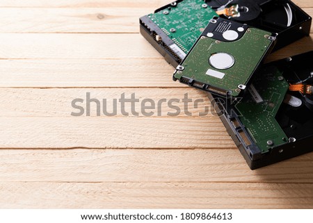 data storage hardware for desktop and laptop computers. backup data technology concept. stack of hard drive disc over wooden background. information recovery conceptual.