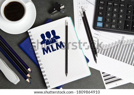 Notebook with a notes MLM on the businessman's Desk. Concept with elements of infographics. The concept of multi-level marketing.