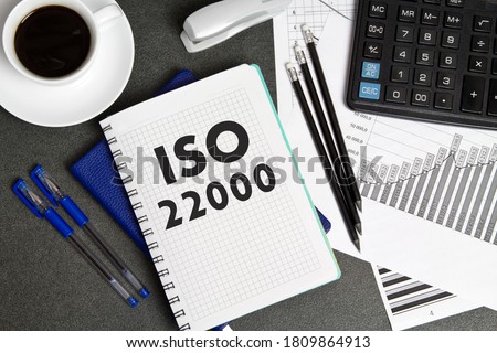 Notebook with a notes ISO 22000 on the businessman's Desk