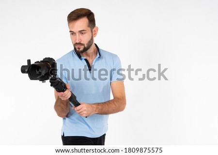 Photographer with a camera and stabilizer in their hands. Male photographer on a white background. Concept - sale of photo cameras. Shooting equipment shop. Sale of stabilizers for cameras.