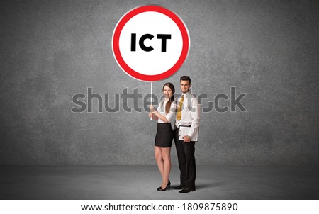 Young business person holdig traffic sign with ICT abbreviation, technology solution concept