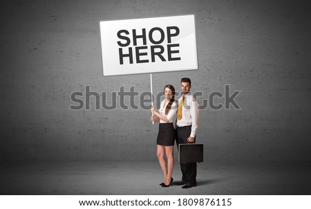 business person holding a traffic sign with SHOP HERE inscription, new idea concept