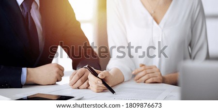 Elderly businessman and group of business people discussing contract in sunny office, close-up