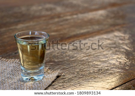 glass of high quality distilled alcohol on the rustic table. Cachaça is a typical drink from Brazil, also known as aguardente. September 13 is the national day of cachaça. Royalty-Free Stock Photo #1809893134