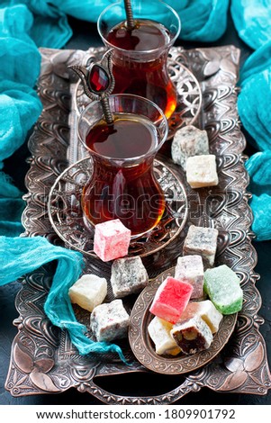 Cups of turkish tea served in traditional style with turkish delights on dark  background