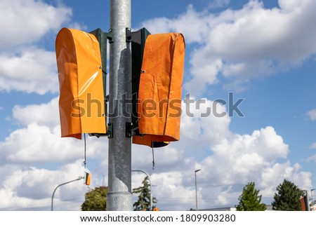 new traffic lights covered with orange plastic bags, outdoors