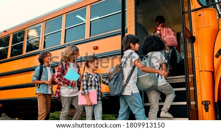 Back to school. Multiracial pupils of primary school near school bus. Happy children ready to study. Royalty-Free Stock Photo #1809913150