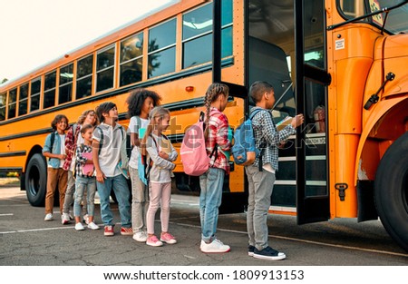 Back to school. Multiracial pupils of primary school near school bus. Happy children ready to study. Royalty-Free Stock Photo #1809913153