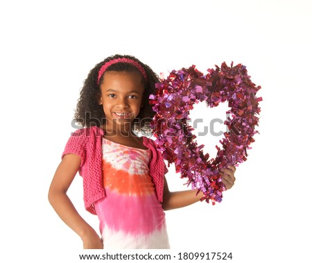 Smiling child holding heart shape, health hope and support concept picture.