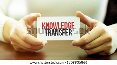 businessman holding a card with text KNOWLEDGE TRANSFER