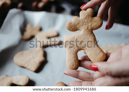 Christmas and New Year holidays, family weekend activities, celebration traditions. Mother cooking festive sweets. Woman hands with freshly baked homemade gingerbread cookies